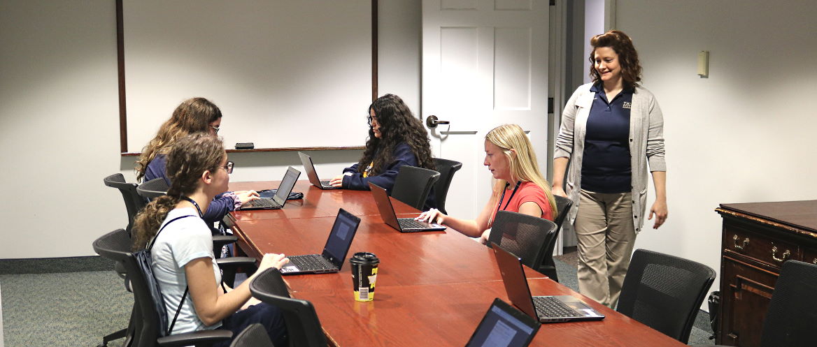 business admin supply chain mang four students in meeting room