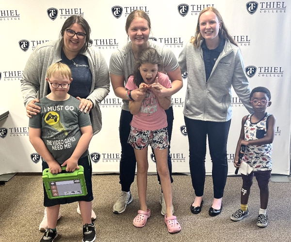 Jillian Pace, Emili Scavito, and Madi Yurich work with children in the Expressive Explorers group designed to support children who use AAC devices in developing effective communication skills.