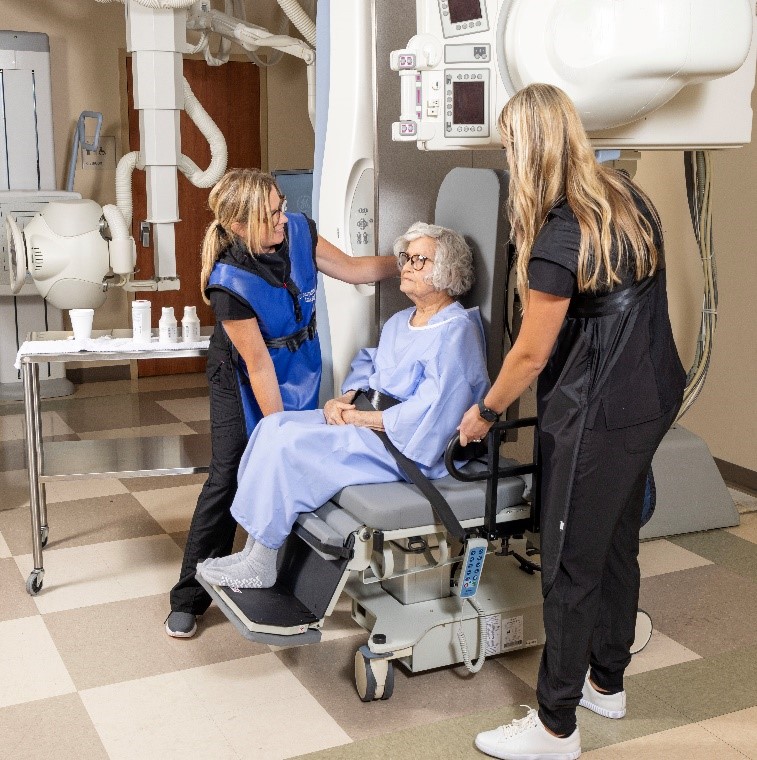 Julie Kobak, MA, CCC-SLP positioning patient for videofluoroscopic study of swallowing.